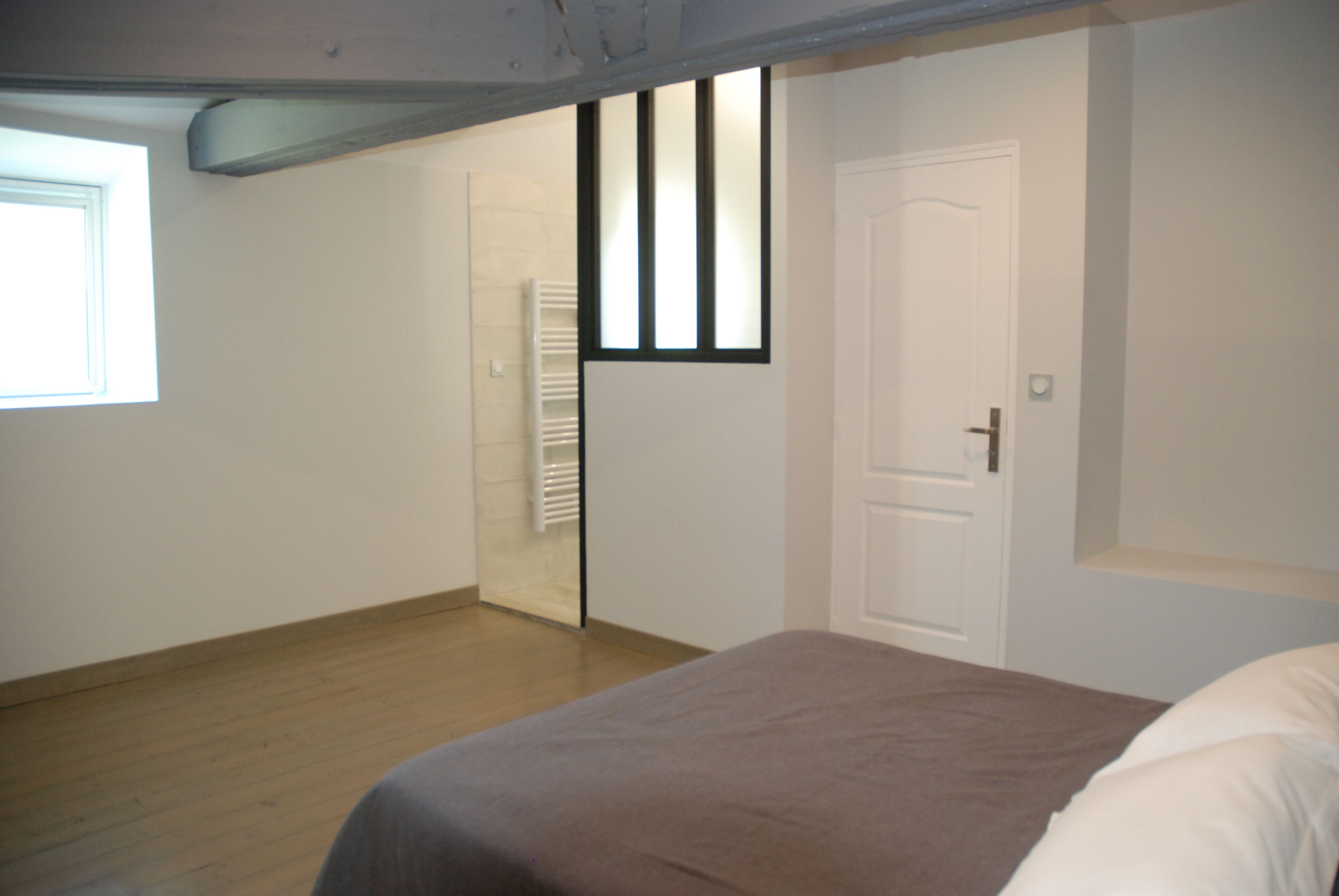 Une chambre à coucher avec un lit, une fenêtre et une porte.