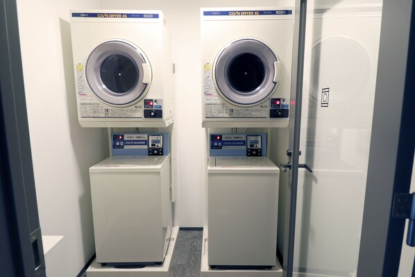 Two identical front-loading washing machines in a laundry room with a door on the right. - Stay SAKURA Kyoto SUZAKU OJI (Kyoto)