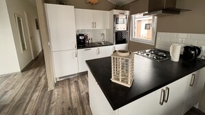 Et moderne køkken med hvide skabe, en sort bordplade og en komfur.