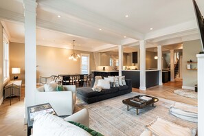 Un grand espace de vie comprenant un canapé, une table basse et un coin repas avec des chaises et une table.