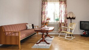 A living room with a sofa, a wooden coffee table, a rocking chair, and a television. - 2 bedroom gorgeous home in Gunnarskog (Gunnarskog)