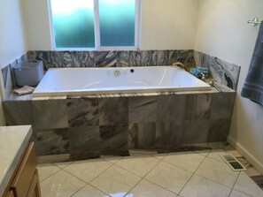 Chuveiro, banheira de hidromassagem, secador de cabelo, toalhas de banho