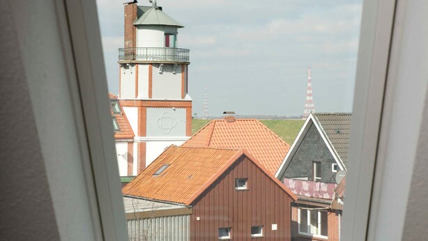 Un tragaluz con vistas a edificios y una torre.