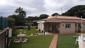 A house with a tiled roof, a fenced yard, and a small garden with a fountain and potted plants. - Large house with private garden / pool at 1500 meters from the sea (Playa de Aro) (Calonge)