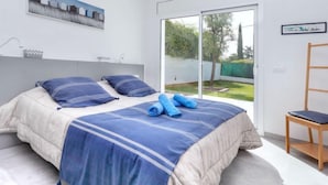A bedroom with a bed, a chair, and a view of the outdoors. - Almendro by Interhome (Sta Cristina d'Aro)