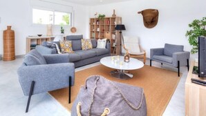 A modern living room with a grey sofa, a coffee table, and a bookshelf. - Almendro by Interhome (Sta Cristina d'Aro)