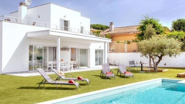 A modern house with a swimming pool, a patio with lounge chairs, and a garden. - Almendro by Interhome (Sta Cristina d'Aro)