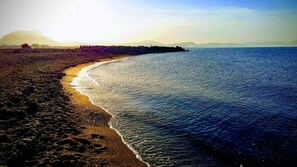 Ein Strand mit felsiger Küste und ruhigem Wasser.