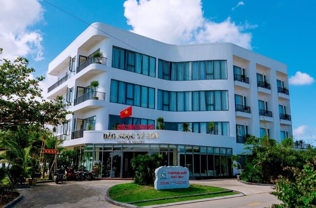 Un hotel moderno con varios pisos, ventanas amplias y balcones.