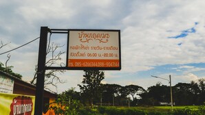 A signboard with Thai text and a contact number. - Bannkrithamed Chiangmai (Hang Dong)