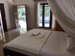 Une chambre d’hôtel avec un lit, une vue sur une piscine et une porte donnant sur l’extérieur.