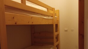 A bunk bed with a wooden frame and a mattress. - Studio cabin 4 pers, mountain view, ski access (La Joue du Loup)