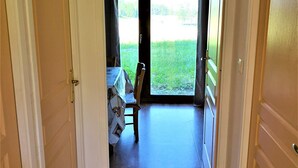 A hallway leading to a dining area with a table set for two and a chair. - Studio cabin La Joue du Loup, 4 ppl., terrace, parking (La Joue du Loup)