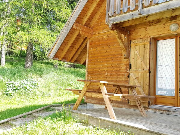 A wooden cabin with a balcony, a wooden deck, and a door with glass panels. - Duplex chalet 3 rooms for 7 pers. with terrace and free parking (La Joue du Loup)