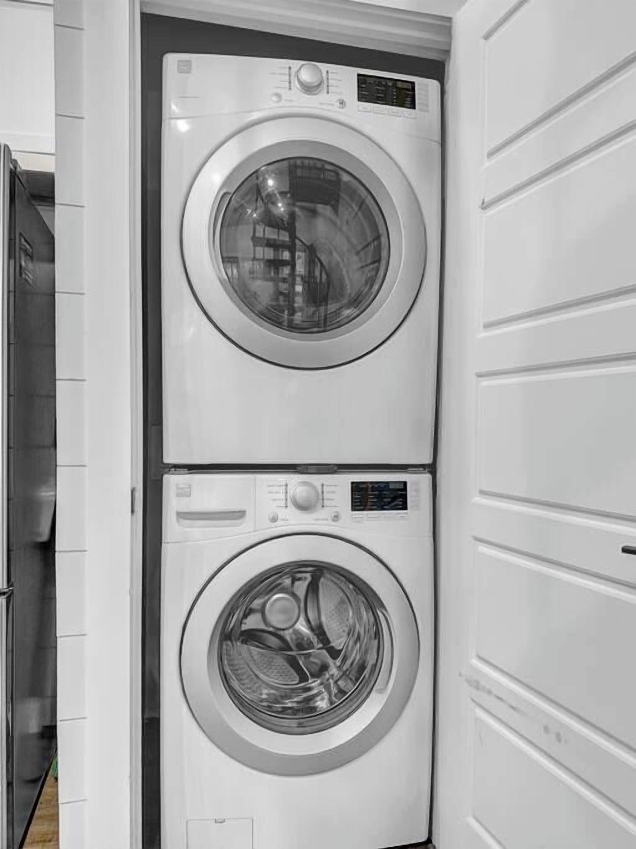 Une machine à laver et un sèche-linge superposés dans une buanderie.