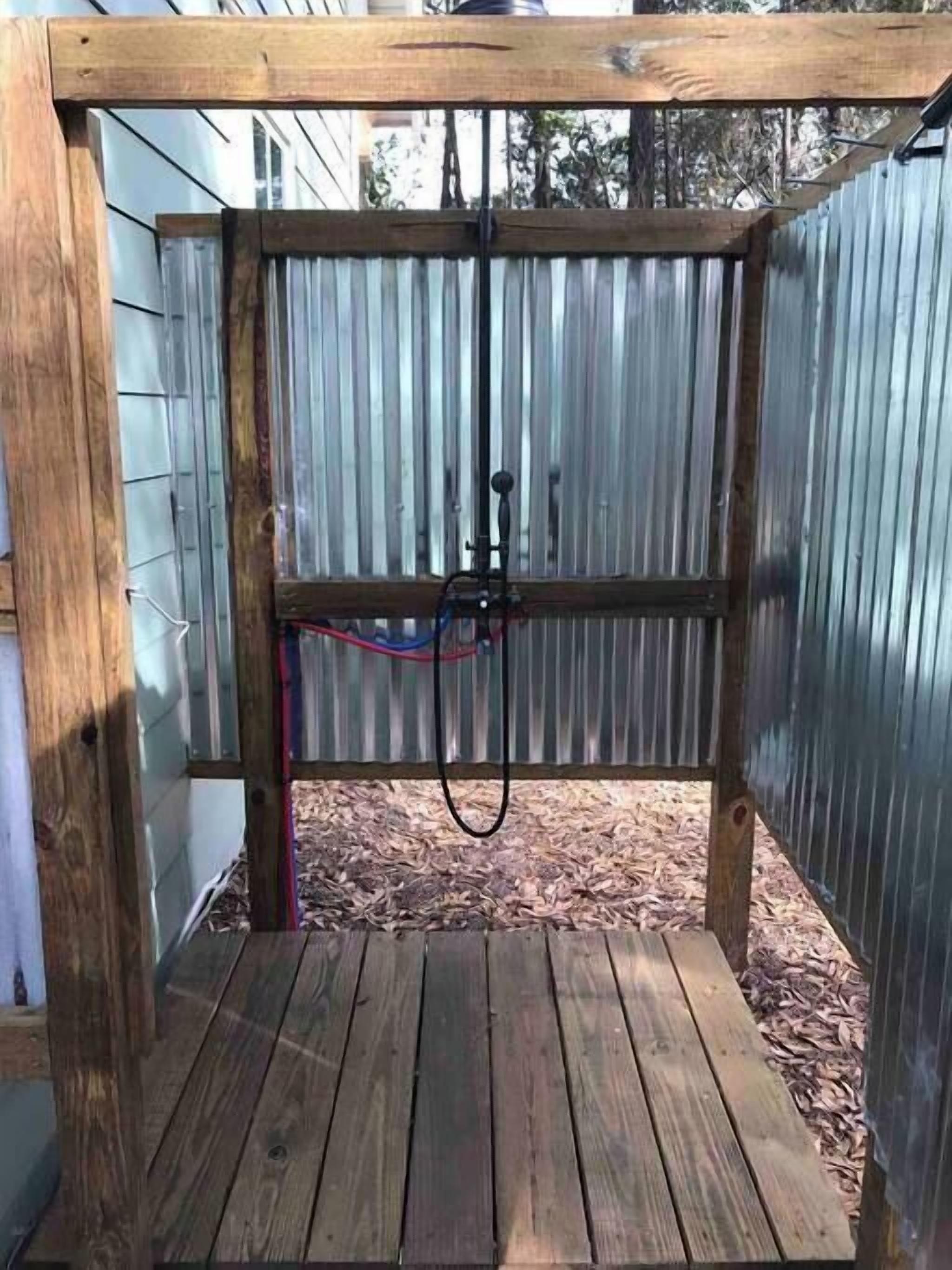 A wooden deck with a metal fence and a hose.