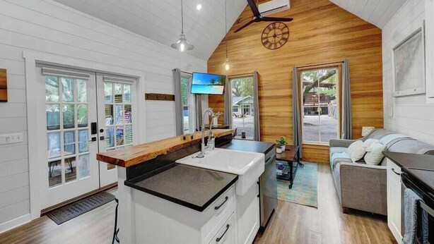 A modern kitchen with a central island, wooden ceiling, and large windows. - Private Hot Tub Island Cottage Near Folly Beach (Charleston)