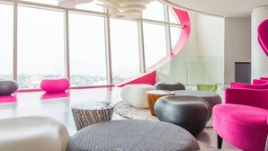 Un interior moderno con amplios ventanales, mobiliario contemporáneo y vistas a la ciudad.