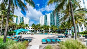 A resort with multiple high-rise buildings, a central pool area, and numerous lounge chairs. - Oceanfront, heated pool & Sea Breeze balcony (Hollywood)