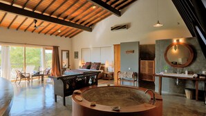 A spacious living area with a large round bathtub, a pool table, and a dining area with chairs. - Highland Villa (Weligama)