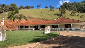 Ein Gebäude im Kolonialstil mit rotem Ziegeldach, einem gepflasterten Innenhof und einer Rasenfläche mit einer Palme.