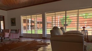 Ein Zimmer mit großem Fenster, Ledermatte und einer Couch.