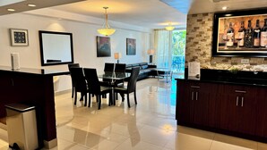 A modern kitchen with a dining area, a sofa, and a large window. - SUNNY ISLES CONDO-RESORT (PARKING INCLUDED) (Sunny Isles Beach)