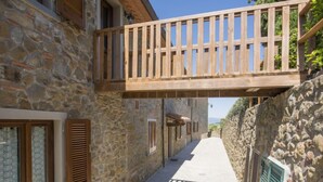 Ein schmaler Steinweg, gesäumt von Gebäuden mit Holzhokken und einem hölzernen Balkon.