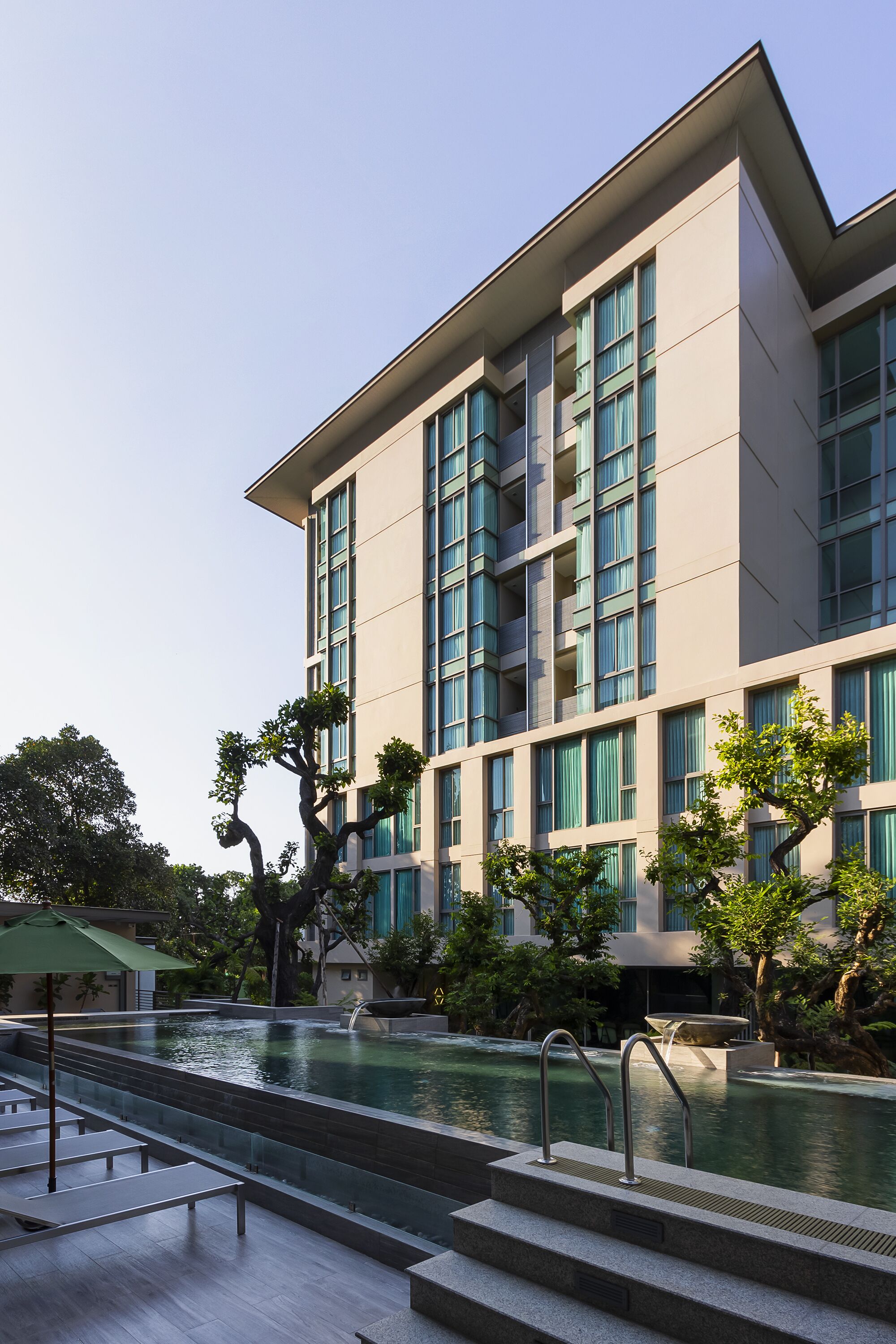 Una piscina al aire libre, sillones reclinables de piscina