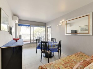 Une chambre avec un lit, une table à manger avec des chaises, un téléviseur et un balcon avec vue.