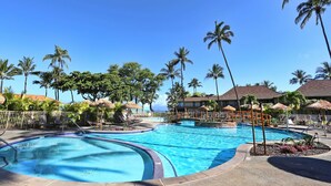 A resort pool area with multiple swimming pools, palm trees, and lounge chairs. - Dine in paradise on your garden-view lanai (Lahaina)