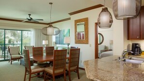 Habitación de hotel con comedor, cocina y balcón.