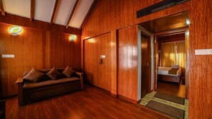 A wooden-floored hallway with a sofa and a bed visible through an open door. - Bowfin Resort (Port Blair)