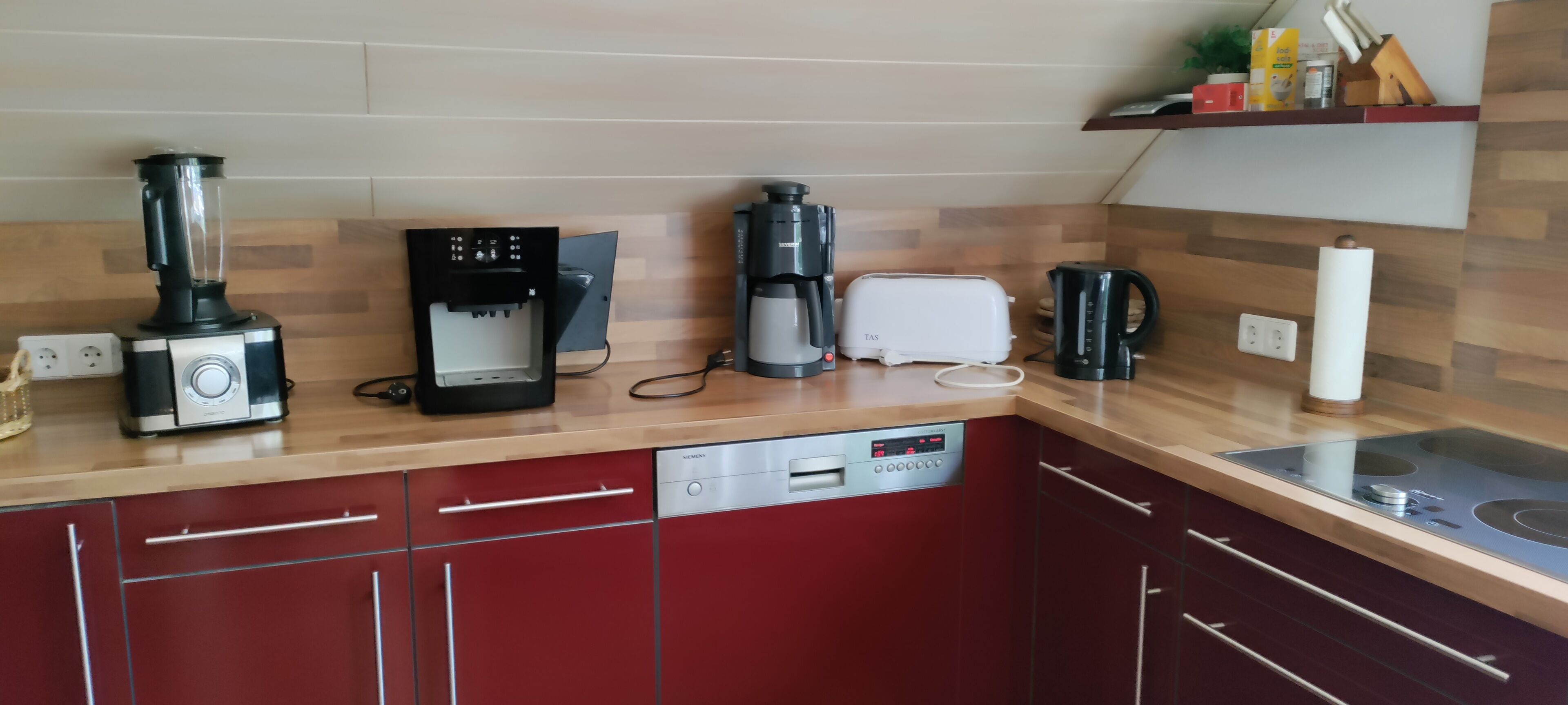 A kitchen with a coffee maker, toaster, blender, and dishwasher.