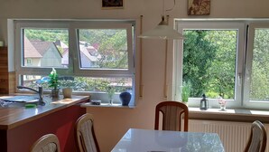 A kitchen with a window, a sink, and a dining area with chairs and a table.