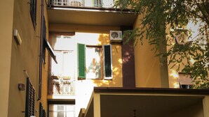 Un patio con una fuente, asientos al aire libre y un edificio con balcones.