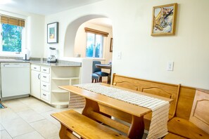 A kitchen with a wooden table, bench, and a view of the dining area. - Downtown Santa Fe, Walk to Plaza, 2B / 2B + Full Kitchen, AIr Conditioned (Santa Fe)