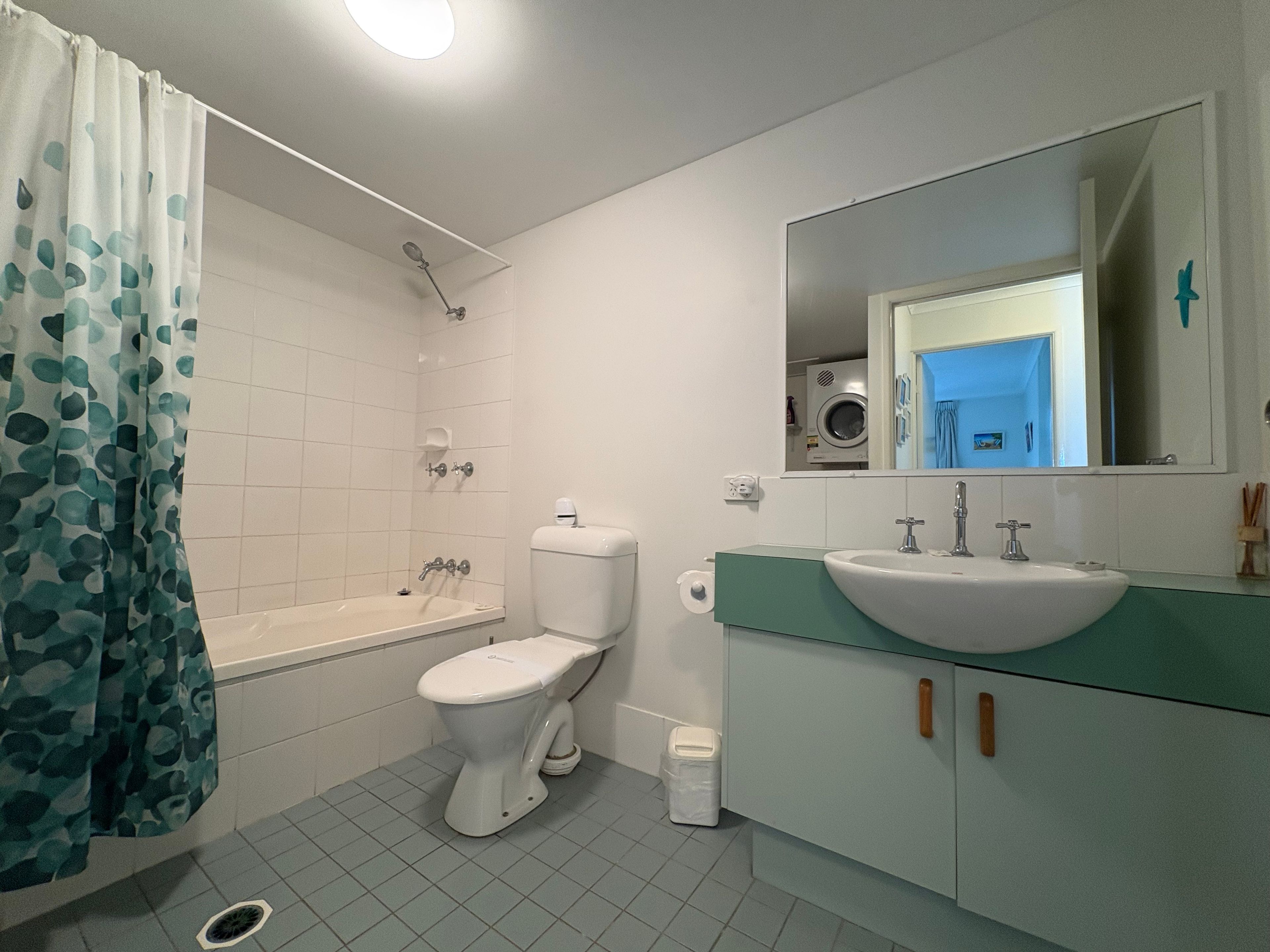 A bathroom with a bathtub, toilet, sink, and a mirror.