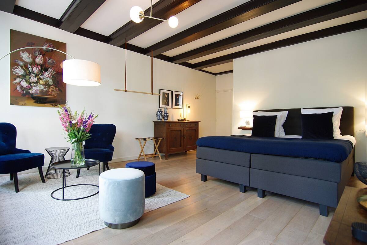 A modern living room with a sofa, two armchairs, a coffee table, and a lamp.