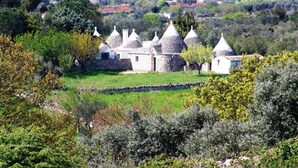 A rural landscape with stone buildings and a stone wall.