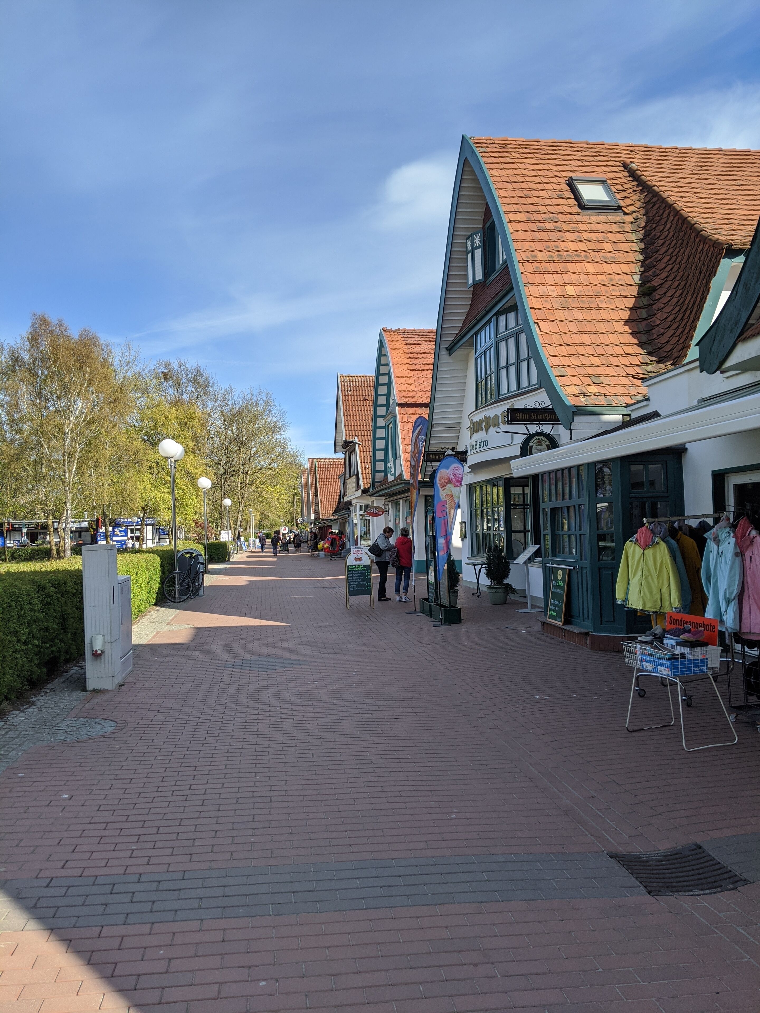 Eine Fußgängerzone gesäumt von traditionellen Gebäuden, darunter Geschäfte und Cafés.