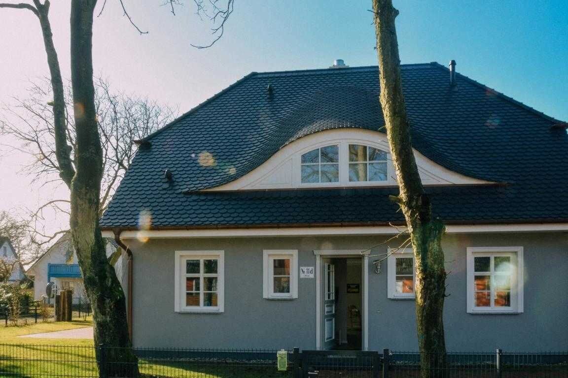 A two-story house with a dark roof, white trim, and a small front porch.