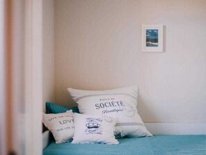 A bedroom with a bed, pillows, a framed picture on the wall, and a window. - Haus Fock - HausFock (Prerow)