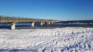 A pier extending into a snowy beach with clear skies. - Haus Fock - HausFock (Prerow)