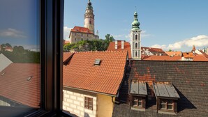 Vista de un paisaje urbano con una torre destacada e iglesia con cúpula verde.