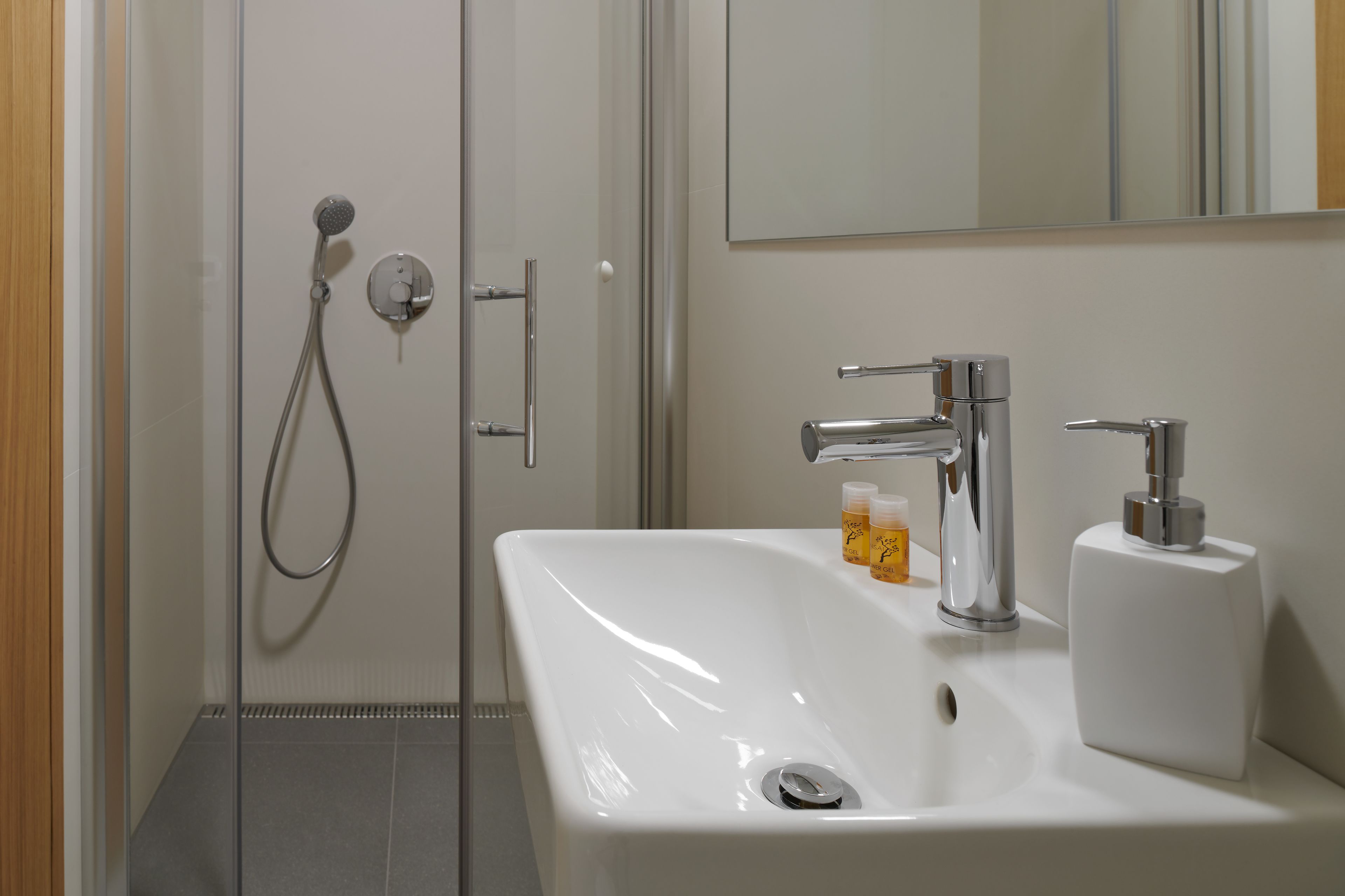 A bathroom with a shower, a sink, and a mirror.