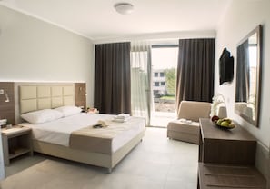 A modern hotel room with a large bed, a desk, a chair, and a balcony with curtains. - Perla Halkidiki (Kassandra)