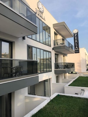 A modern hotel with multiple balconies, large windows, and a clear sky. - Perla Halkidiki (Kassandra)