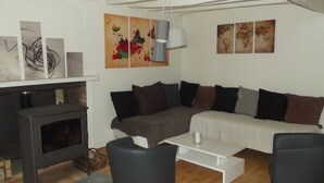 A modern living room with a fireplace, a white sofa, and a coffee table. - Le Domaine de Jaugy - Hostel (Gievres)