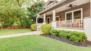 A two-story house with a porch, a flag, and a mailbox.